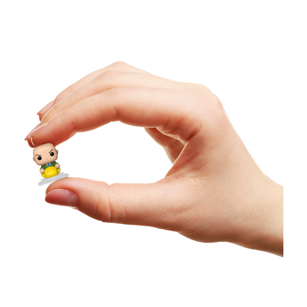 Hand holding a small figurine against a white background