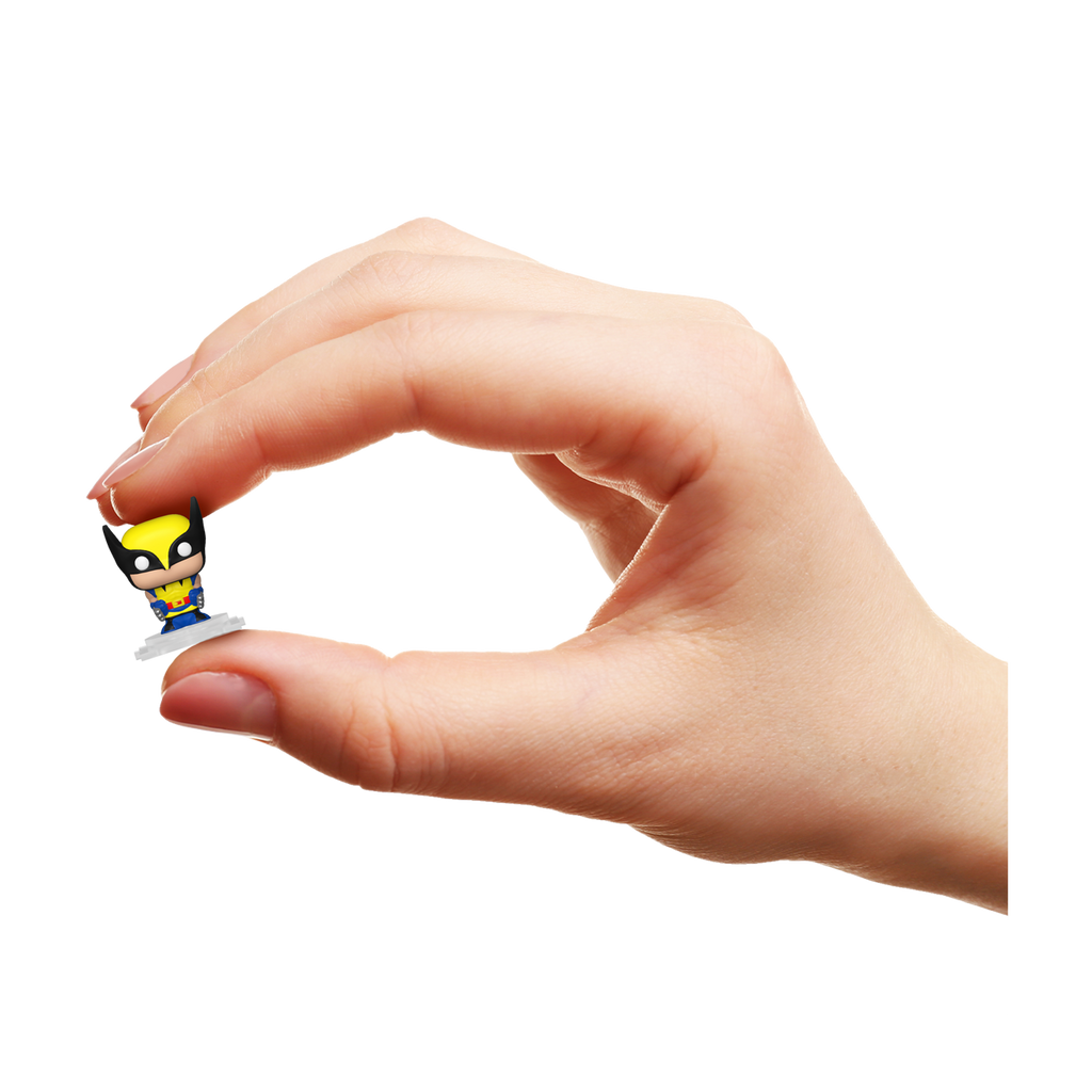 Hand holding a small superhero figurine against a white background
