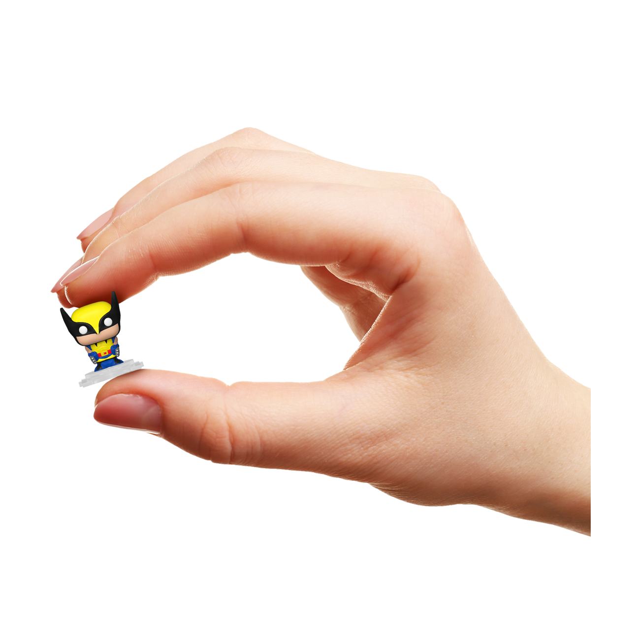 Hand holding a small superhero figurine against a white background